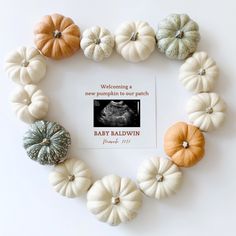 there are many small pumpkins arranged in the shape of a heart with a card