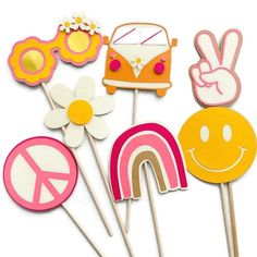 a bunch of cake toppers with some flowers and peace signs on them in front of a white background