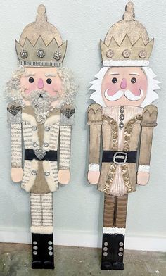 two wooden nutcrackers are standing next to each other on the floor in front of a wall