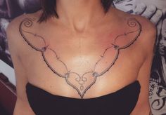 a woman's chest with an intricate design on the top and bottom part of her breast