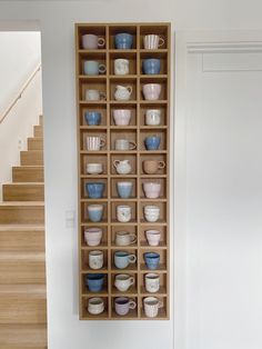 a wooden shelf filled with lots of cups