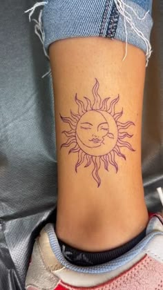 a woman's foot with a sun tattoo on the side of her leg,