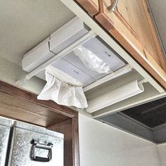 an air conditioner mounted to the side of a kitchen cabinet above a stove top