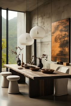 a dining room table with two vases sitting on it's sides and four chairs around it