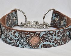 a blue and brown dog collar with an ornate design on the front, silver chain at the end