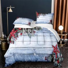 a bed covered in blue and white comforter next to a night stand with christmas decorations on it