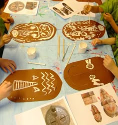 children are making gingerbreads at a table with paper plates and spoons on it