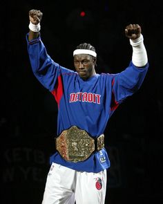 professional wrestler in blue and white outfit holding his fist up