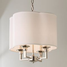 a chandelier with three lights hanging from it's sides and a white shade