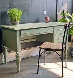 a desk with a chair and potted plants