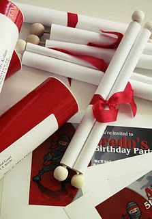 the birthday party favors are wrapped in red and white paper, with candy sticks sticking out of them