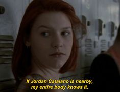 a woman with red hair standing in front of lockers