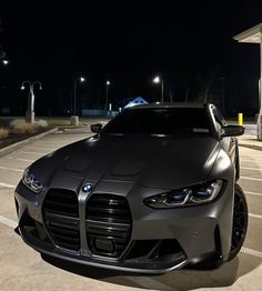 a car parked in a parking lot at night with its hood up and lights on