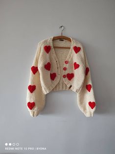 a white sweater with red hearts on it