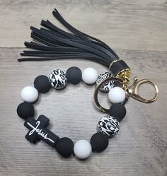 a black and white beaded bracelet with a keychain on top of it