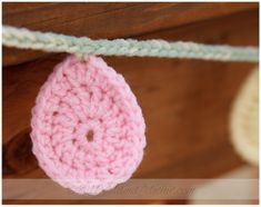 a pink crocheted object hanging from a string