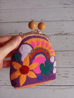 a hand holding a small purse with beads on it