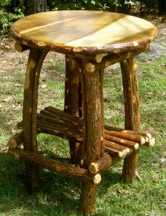 a wooden stool made out of logs in the grass next to a tree stump table