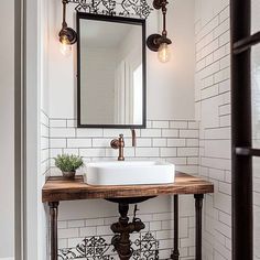 a bathroom sink sitting under a mirror on top of a wooden counter next to a white tiled wall