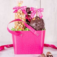 a pink bag filled with chocolates and candies on top of a white table