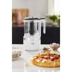 a pizza sitting on top of a table next to a blender