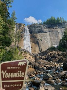 a sign that is in front of a waterfall