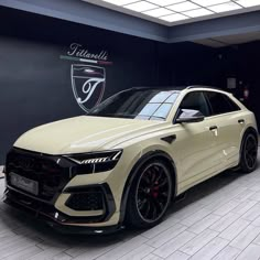 a white car parked in front of a black wall