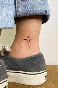 a woman's foot with a small flower tattoo on her left side ribcage