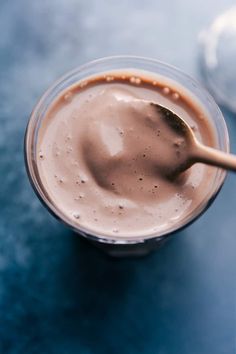 a spoon in a cup with chocolate pudding