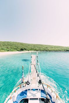 the back end of a boat traveling through clear blue water