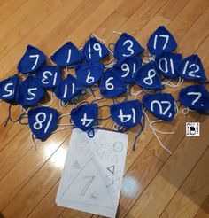 a bunch of blue numbers are sitting on the floor next to a piece of paper