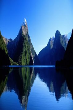 the mountains are reflected in the still water