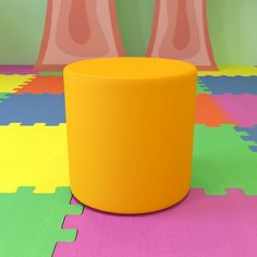 an orange stool sitting on top of a brightly colored floor covered in puzzle pieces and pink vases