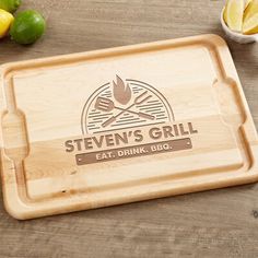 a wooden cutting board with the words stevens's grill on it next to lemons and limes