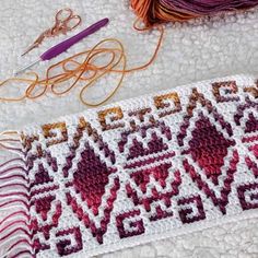 some yarn and scissors are laying on the ground next to an item that says love