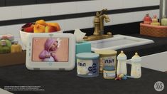 a computer monitor sitting on top of a counter next to baby bottles and food containers