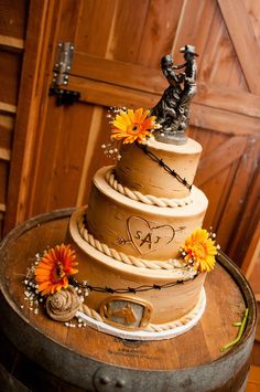 a three tiered cake on top of a wooden barrel