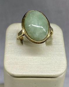 VINTAGE Jade 14k Solid Hold Oval Cabochon Ring  This beautiful ring features a stunning oval-shaped natural jade stone set in a 14k yellow gold bezel setting. The stone measures 14mm in length and 10mm in width, with a tapering band width of 2.5mm to 1.5mm. The ring weighs 2.88 grams or 1.85 dwt.    The authentic jade stone is the centerpiece of the ring, with no additional gemstones. Oval Jade Rings In Yellow Gold, Vintage 14k Gold Oval Cabochon Emerald Ring, Vintage 14k Gold Emerald Oval Cabochon Ring, Antique Oval Emerald Ring Stamped 14k, Vintage Oval Emerald Ring In 14k Gold, Classic Oval Emerald Collectible Ring, Classic Oval Emerald Ring Collector's Item, Vintage Oval Jade Emerald Ring, Vintage Oval Jade Rings