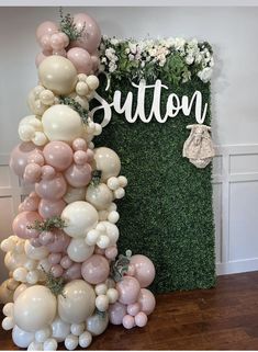 balloons and greenery are arranged in the shape of a sign that says sutton