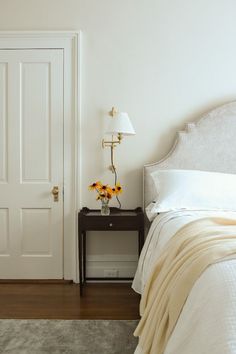 a white bed sitting next to a door in a bedroom