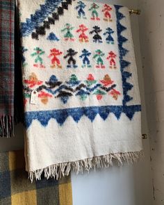 two towels hanging on the wall next to each other with different colored designs and colors