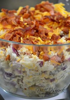 a bowl filled with bacon and cheese on top of a table