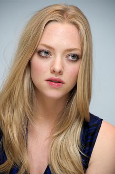 a woman with long blonde hair and blue eyeshadow is looking at the camera