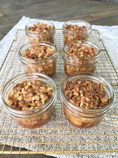 four jars filled with granola sitting on top of a table