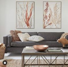 a living room with two paintings on the wall and a coffee table in front of it