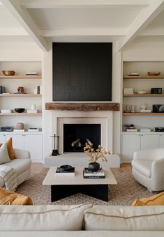 a living room filled with furniture and a fire place under a flat screen tv mounted above a fireplace