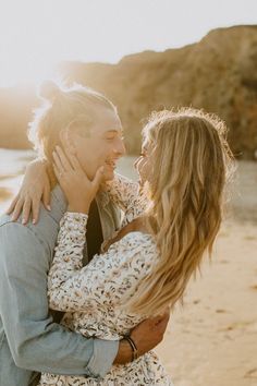 a man and woman embracing each other on the beach