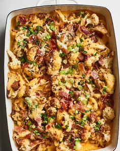 a casserole dish with cauliflower, bacon and green onions in it