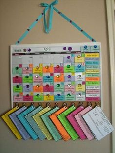 a calendar hanging on the wall with pins attached to it's sides and ribbons