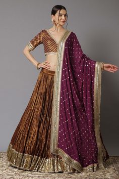 Gold tiered lehenga with gota patti border and scallop detail. Comes with wine blouse and dupatta.
Component: 3
Pattern: Embroidery
Type Of Work: Sequin and Gota Patti
Neckline: V neck
Sleeve Type: Half
Fabric: Metallic Chanderi and Chinon; Lining: Shantoon and Cotton
Color: Purple,Gold
Other Details: 
Dupatta with embroidered border
Low back with tie up and tassels
Closure: Back hook
Occasion: Wedding - Aza Fashions Wine Color Combination, Wine Lehenga, Chanderi Lehenga, Latest Bridal Lehenga, Cotton Lehenga, Purple Metallic, New Address, Embroidered Wedding, Wedding Lehenga